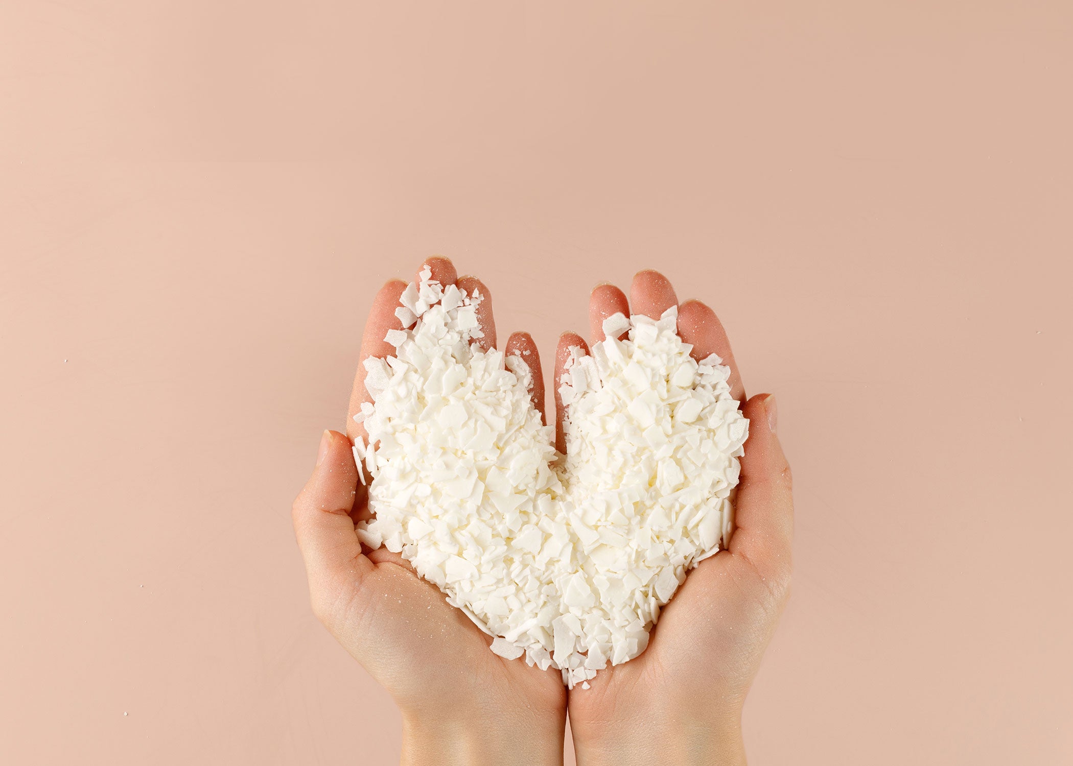 This picture is of hands holding flakes of all natural soy wax like what Candle Castle & Co in Chicago uses during their Candle Making Classes,