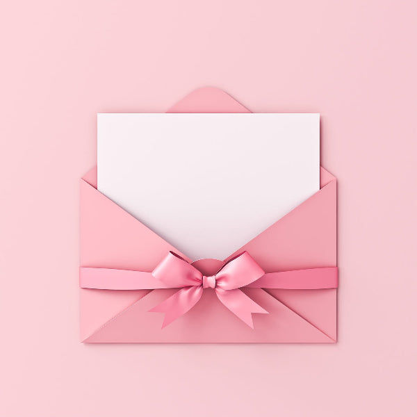 Pink envelope with a white card and pink ribbon on a pink background