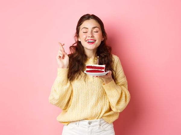 Girl holding cake and making a wish